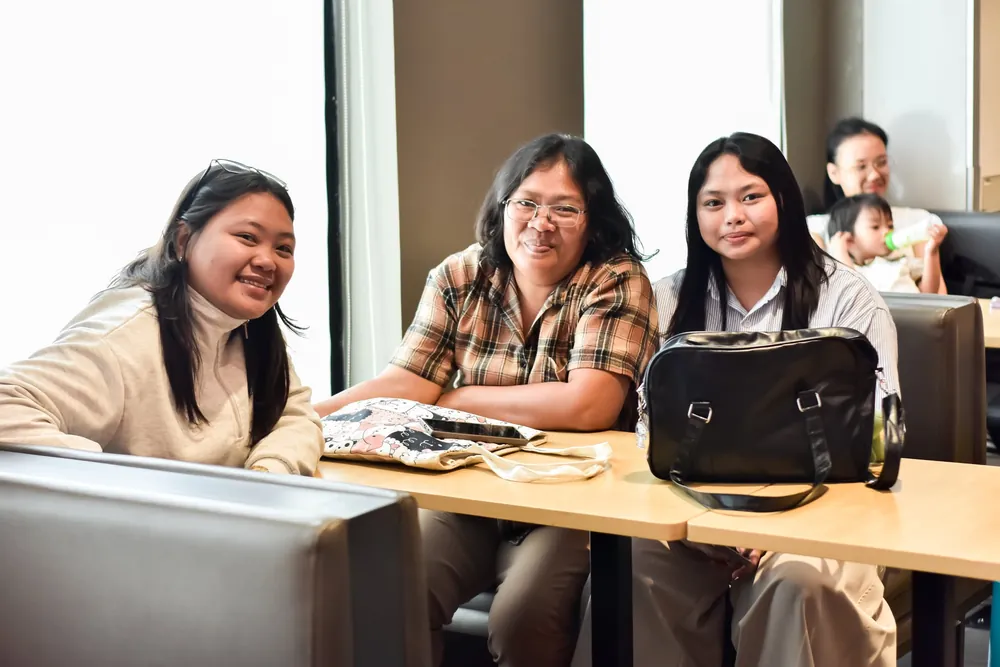Guests smiling candidly at a table during a birthday celebration in Imus