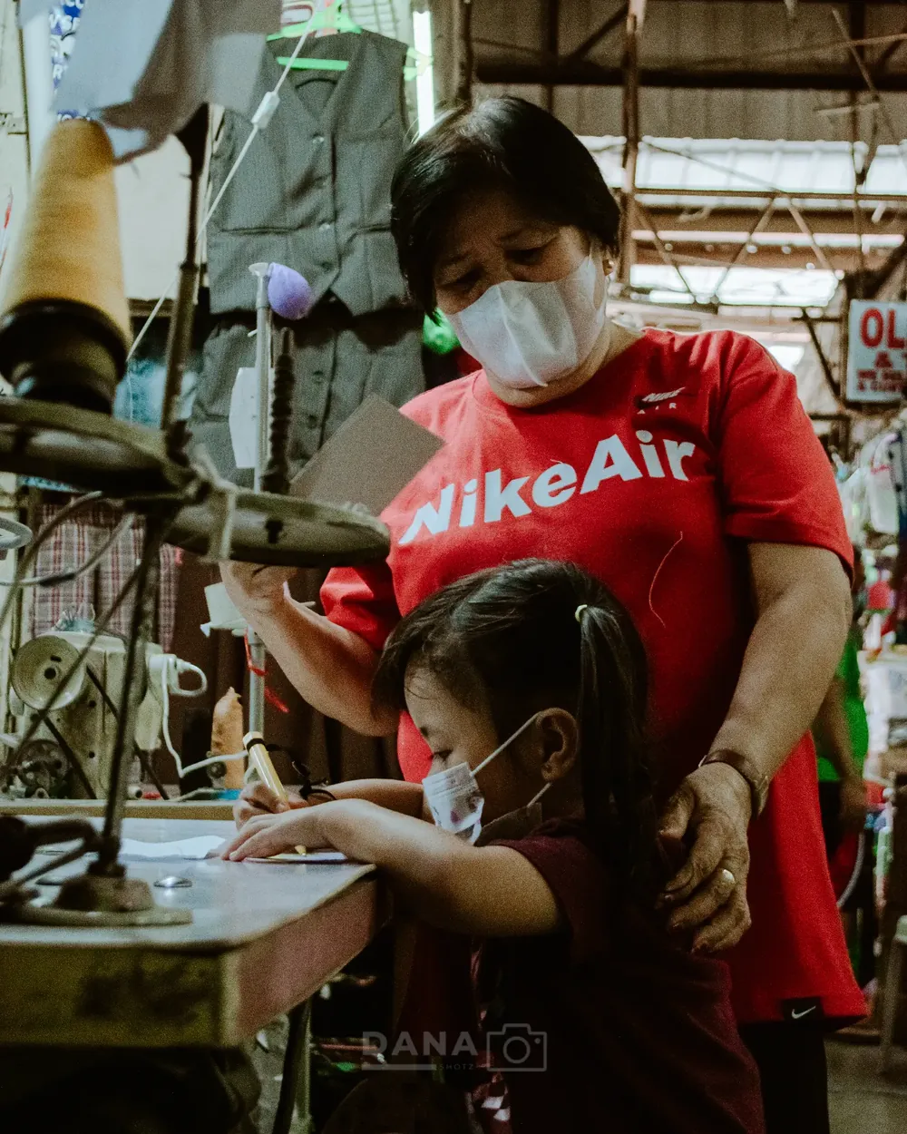 Candid documentary photo of a mother and daughter working at a workshop in Cavite